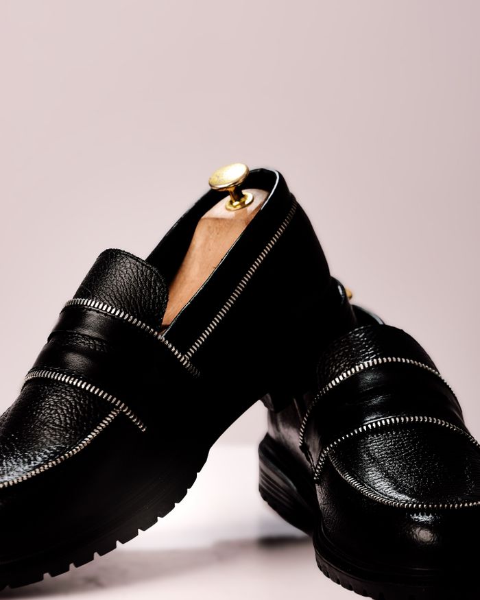 Stylish black leather loafers with gold accents for a classy, modern look.