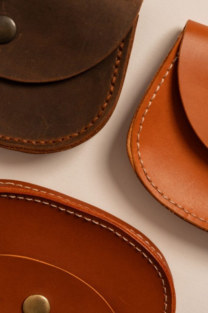 Detailed view of three handcrafted leather pouches showcasing different textures and colors.