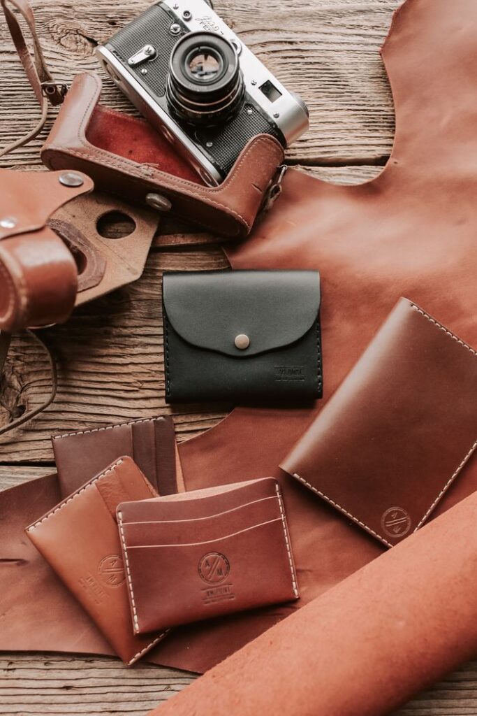 Artistic display of handcrafted leather wallets and vintage camera.